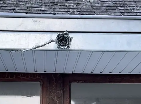 Rose en zinc façonnée à la main, soudée sur le bandeau d'une lucarne