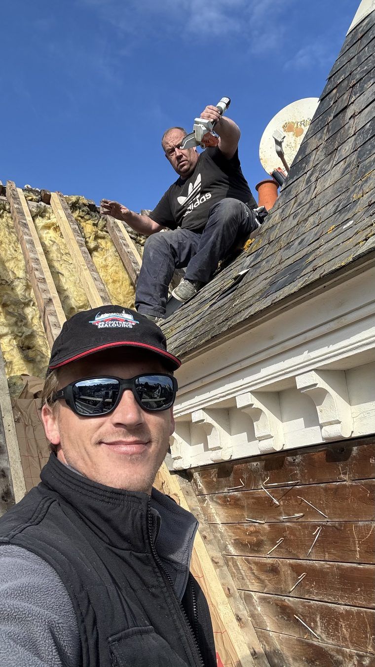 Deux couvreurs de l'équipe des Couvreurs Malouins sur un chantier de réfection, corniche moulurée et isolation en cours