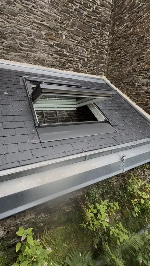 Fenêtre de toit VELUX dans une couverture en ardoise neuve